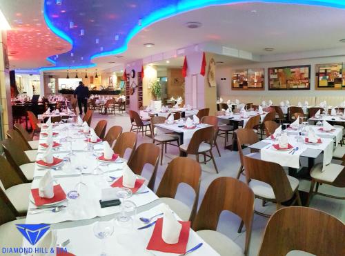 a dining room with white tables and chairs at Diamond Hill Resort & SPA in Vlorë