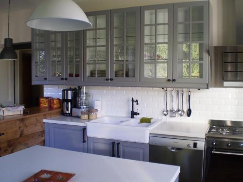 a kitchen with blue cabinets and a white sink at Chambres d'Hôtes le Clos des Lesses in Fresse-sur-Moselle