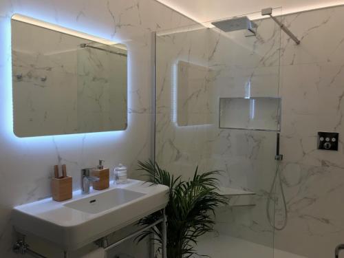 a white bathroom with a sink and a shower at Luxurious Townhouse 10 mins walk to Epernay centre in Épernay