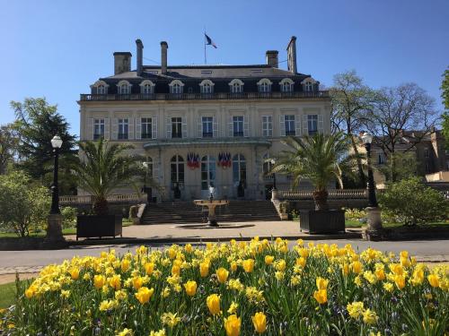 a building with a bunch of flowers in front of it at Luxurious Townhouse 10 mins walk to Epernay centre in Épernay