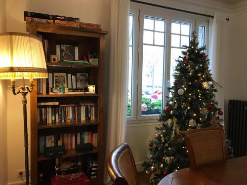 a christmas tree in a living room with a window at Luxurious Townhouse 10 mins walk to Epernay centre in Épernay