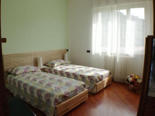 2 camas en una habitación con ventana en Appartamento Sari, en Como