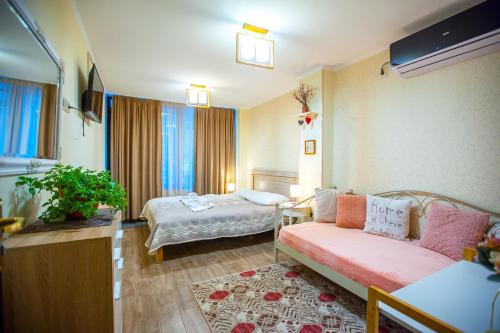 een woonkamer met een bank en een bed bij Apartments Beautiful Tbilisi on L.Meskhishvili Turn 1 in Tbilisi City