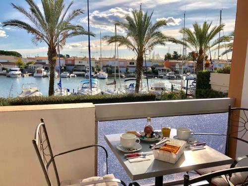 een tafel op een balkon met uitzicht op een jachthaven bij Cap Capistol Studio le Cap d'Agde vue port in Cap d'Agde