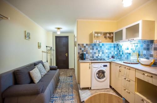 a kitchen with a couch and a washing machine at Apartments Beautiful Tbilisi on L.Meskhishvili Turn 1 in Tbilisi City