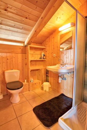 La salle de bains en bois est pourvue de toilettes et d'un lavabo. dans l'établissement Le Mazot de Marie - chalet 6 pers, à Flumet