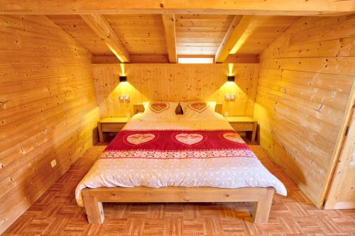 a bedroom with a bed in a wooden cabin at Le Mazot de Marie - chalet 6 pers in Flumet
