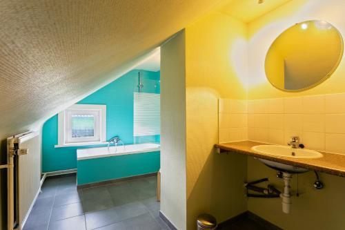 uma casa de banho com um lavatório e um espelho em 't Verderf em Maarkedal