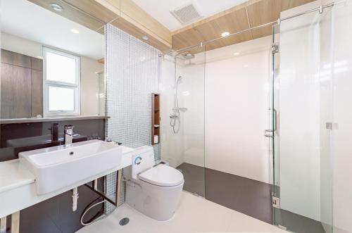 a bathroom with a toilet and a sink and a shower at Sitthinard Grandview Hotel in Phatthalung