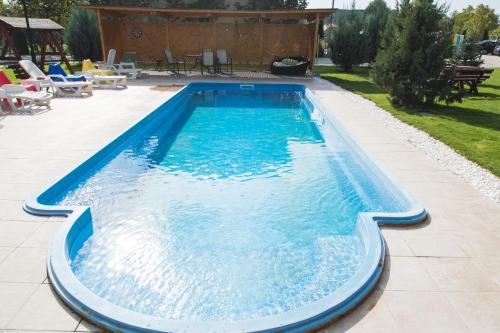 a swimming pool with blue water in a yard at Airport Residence - Apartment across from Otopeni Airport in Otopeni
