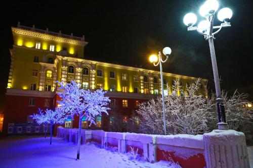 a building at night with snow covered trees and lights at Центр г Норильска Ленинский 24 in Noril'sk