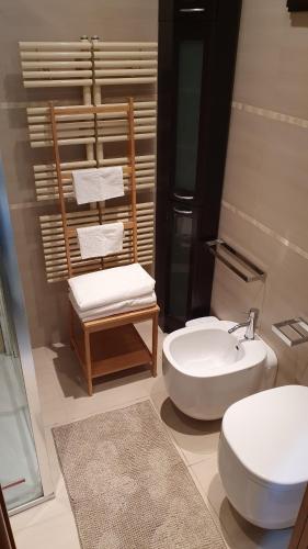 uma casa de banho com um lavatório, um WC e uma cadeira. em La casa del vicolo - Taormina centro em Taormina