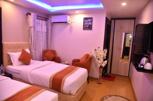 a hotel room with two beds and a tv at Marinha Airport Hotel in Kathmandu