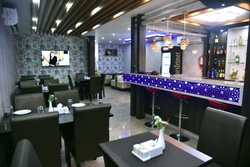 a restaurant with tables and chairs and a bar at Marinha Airport Hotel in Kathmandu