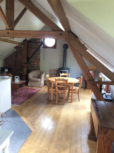 Una sala de estar con una mesa y sillas de madera. en Gîte Saint-Martin de la Fauvette, en Leuze-en-Hainaut