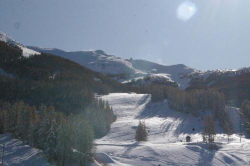 a snow covered mountain with trees and a snow covered slope at Studio Le Boussolenc in Les Orres