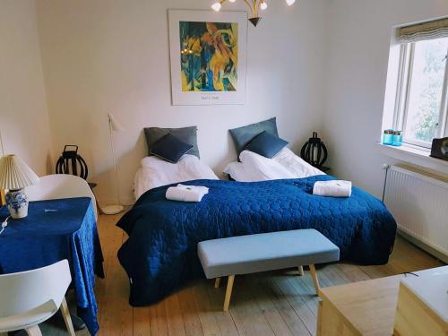 a bedroom with a blue bed with a blue comforter at Koege Guesthouse in Køge