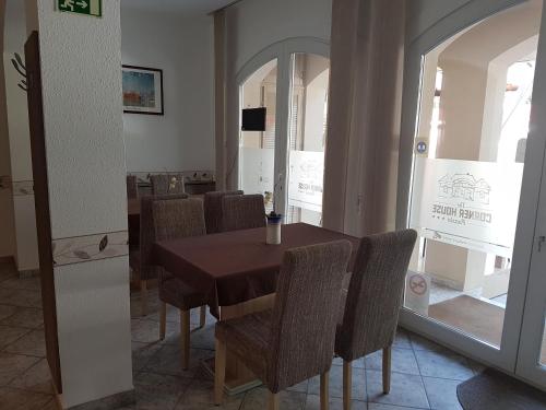 a dining room with a wooden table and chairs at The Corner House Panzió in Tata