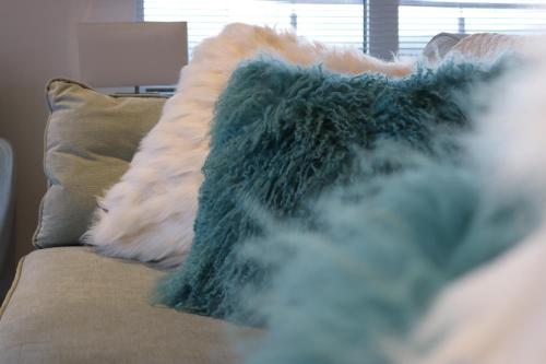 a blanket sitting on a couch with a pillow at 19 Ocean Gate in Newquay