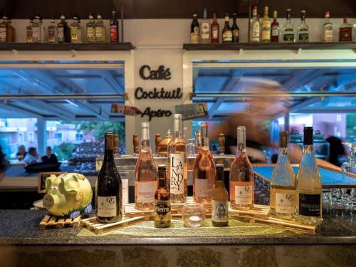 a display of bottles of wine on a bar at Ferienhotel Maristella in Algajola