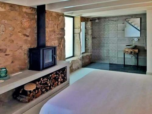 Habitación con baño con chimenea y TV. en River House Sejães, en Oliveira de Frades