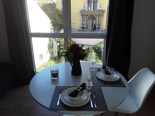 a white table and chairs in front of a window at ZAGRABY APARTMENT in Zagreb