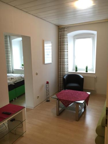 ein Wohnzimmer mit einem Stuhl und einem Tisch in der Unterkunft Gemütliches Appartement nähe Zentrum mit Küche in Haßfurt