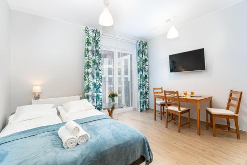 sypialnia z łóżkiem, stołem i krzesłami w obiekcie STEAM PARK Krakow Apartment w Krakowie