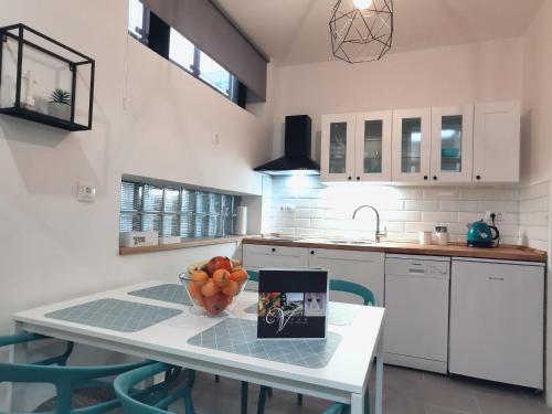 a kitchen with a table with a bowl of fruit on it at Goreta032 Apartment in Vukovar