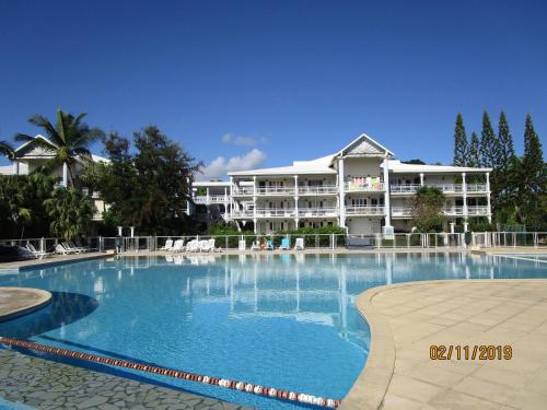 a large swimming pool in front of a large building at Le Mabouya in Saint-François