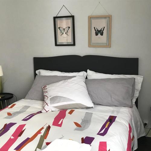 - une chambre avec un lit avec 2 papillons sur le mur dans l'établissement Maison Bernadette - Premier Etage, à Vitry-sur-Seine