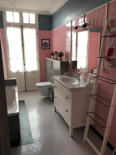 a pink bathroom with a sink and a toilet at Maison Bernadette - Premier Etage in Vitry-sur-Seine