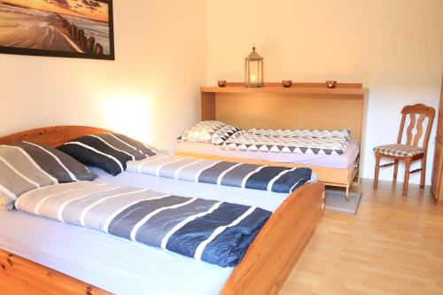 - 2 lits dans une chambre avec une table et une chaise dans l'établissement Ferienwohnung Naturpark Schlei, à Güby