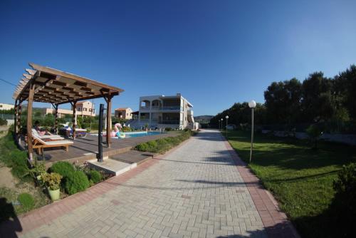 a brick walkway next to a pool and a building at Niovi Seaside Suites in Kissamos
