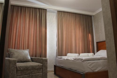 a bedroom with a bed and a chair in it at Green Apartment in Kazbegi