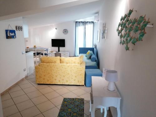 een woonkamer met een gele bank en een tafel bij Villacristiano in Marano Marchesato