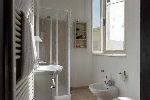 a white bathroom with a sink and a mirror at Da Linda in Livorno