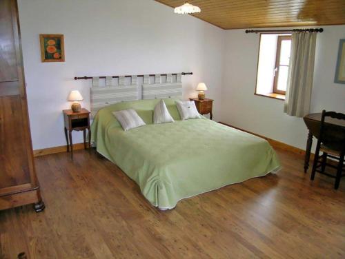 - une chambre avec un grand lit vert et 2 tables dans l'établissement Chambres d'Hôtes Domaine Le Fragnaud, à Saint-Porchaire