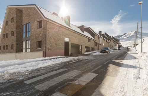 a snowy street with a building in the snow at Lux Isard "Acceso directo a pistas" in Pas de la Casa