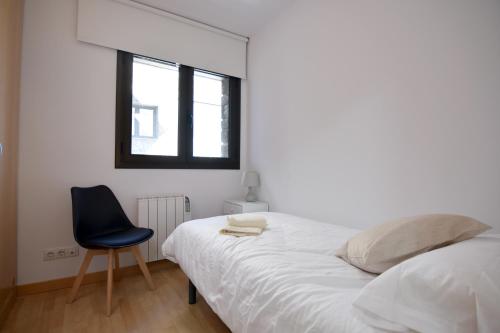 una camera con un letto e una sedia e una finestra di Lux Isard "Acceso directo a pistas" a Pas de la Casa