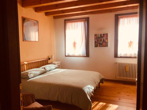 1 dormitorio con 1 cama grande y 2 ventanas en beb - casa vacanze San Gallo, en Farra di Soligo