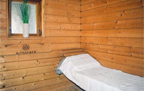 a bed in a wooden room with a window at Gorgeous Home In Tidaholm With Kitchen in Tidaholm