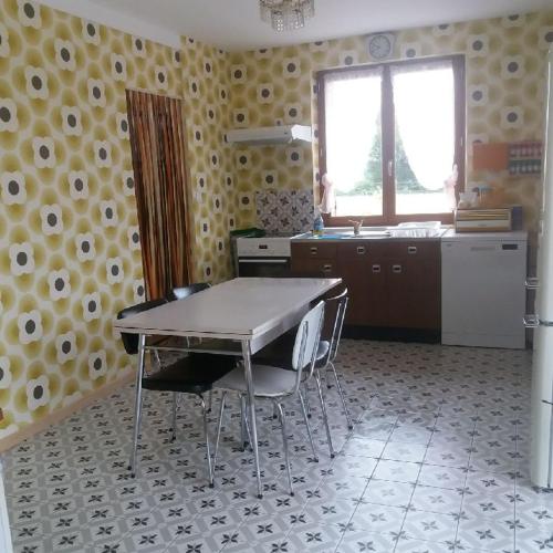 a kitchen with a table and chairs in a room at Gîte Version 70 in Mondrepuis