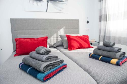a bed with towels and red pillows on it at Playa de Las Americas Luxury Home in Playa de las Americas