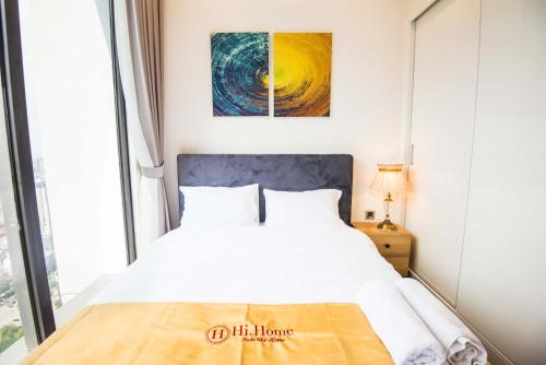 a bedroom with a white bed and a window at Hi-Home Suites - Vinhomes Metropolis in Hanoi