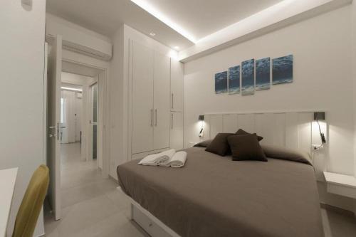 una camera bianca con un grande letto e un corridoio di Casa Azul a San Vito lo Capo