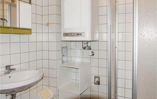 a white tiled bathroom with a sink and a mirror at Stunning Home In St, Martin A,d, Raab With 1 Bedrooms in Neumarkt an der Raab