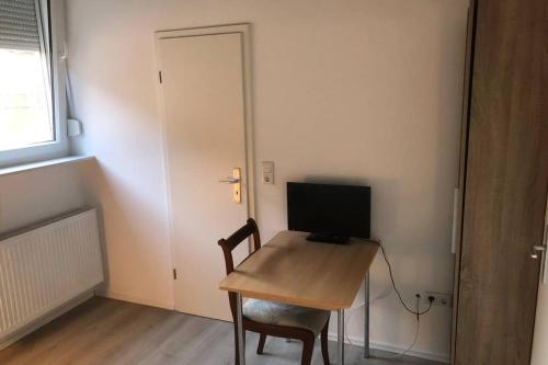 a room with a desk with a computer on it at Zimmer1 in Alzenau in Unterfranken