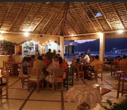 a group of people sitting at tables in a restaurant at Paraiso Azul in Acapulco