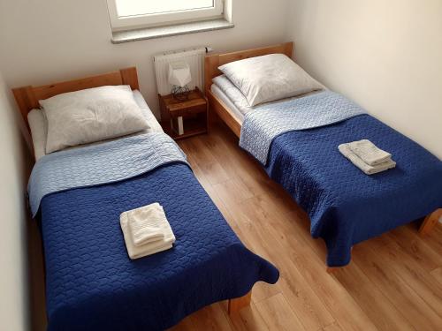 2 letti posti uno accanto all'altro in una camera da letto di GM Apartament Szczecin a Stettino